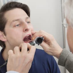 doctor looking into patient's throat
