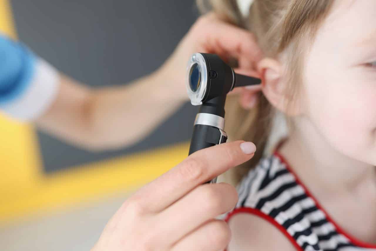 Young girl receiving an ear exam.