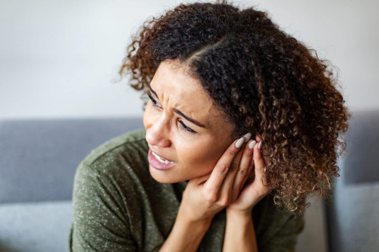 Woman experiencing severe inner ear pain.
