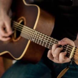 Close-up of a man playing guitar.