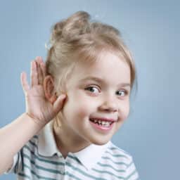 Young girl with a hand to her ear listening