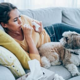 Woman with pet allergies sitting with her dog