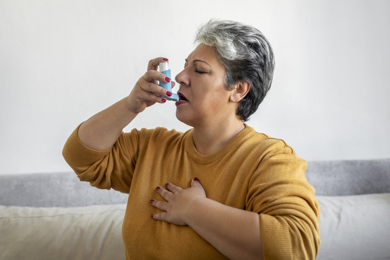 Senior woman using an inhaler.